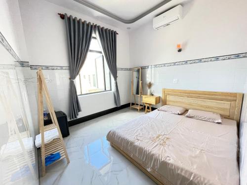 una camera da letto con un letto e una grande finestra di Hải Hưng Homestay - Đảo Phú Quý a Cù Lao Thu