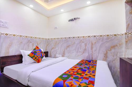 a bedroom with a bed with a colorful quilt on it at FabHotel MN International - Nr Park Circus in Kolkata