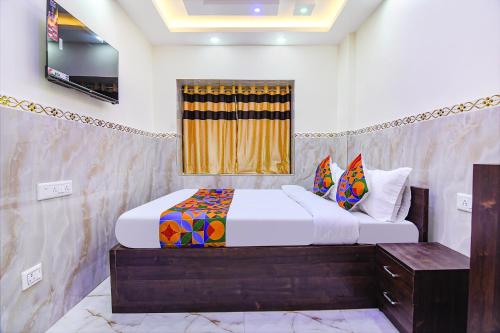 a bedroom with a bed and a television in it at FabHotel MN International - Nr Park Circus in Kolkata