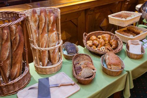 a table with baskets of bread and baskets of pastries at Le Calgary in Les Saisies