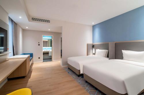 a hotel room with two beds and a television at Holiday Inn Express Jinan Airport Zone by IHG in Jinan
