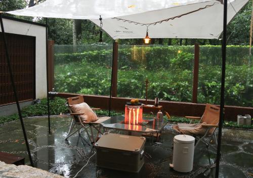 a patio with a table and a white umbrella at Millennium Resort Hangzhou in Hangzhou