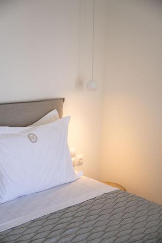 a bedroom with a bed with a white pillow at Makrikythera Luxury Suites - Private Pool or Hot Tub Suites in Dhiakofti