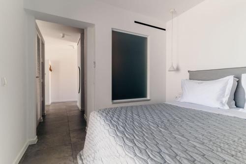 a bedroom with a large bed and a large window at Makrikythera Luxury Suites - Private Pool or Hot Tub Suites in Dhiakofti