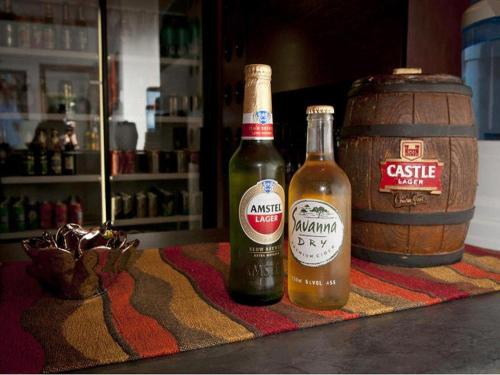 two bottles of beer and a barrel on a table at La Casa Mia Guesthouse in Kimberley