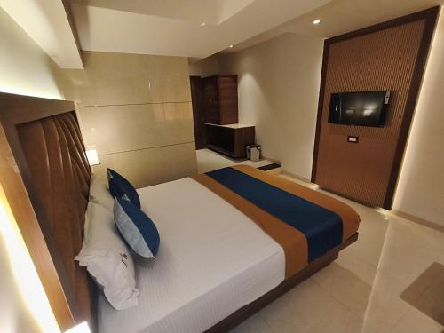 a hotel room with a bed and a television at Nakshtra Residency Kalyan in Kalyan