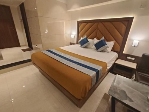 a bedroom with a large bed in a hotel room at Nakshtra Residency Kalyan in Kalyan