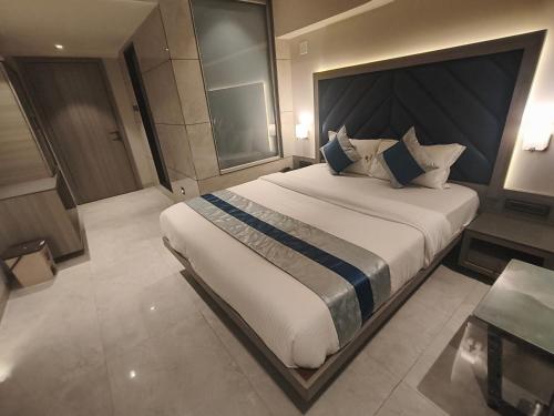 a bedroom with a large bed and a table at Nakshtra Residency Kalyan in Kalyan