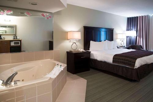 a hotel room with a bed and a bath tub at Country Inn & Suites by Radisson, Effingham, IL in Effingham