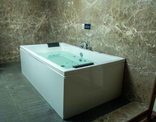 a white tub in a bathroom with a sink at Golden Fields Resort in Mulshi