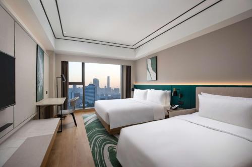 Postel nebo postele na pokoji v ubytování Hilton Garden Inn Xiamen Bailuzhou Park