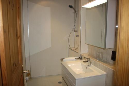 a white bathroom with a sink and a mirror at Ferienwohnung am Ortenaupark in Bad Reichenhall