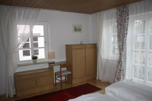 a bedroom with a desk and a bed and a window at Ferienwohnung am Ortenaupark in Bad Reichenhall