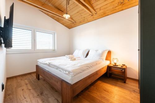 a bedroom with a large bed with white sheets at Chaty Svätý Kríž in Svätý Kríž