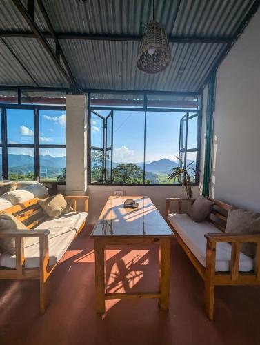 a living room with two beds and a table at Indralok Hotel and Sky Garden in Deorāli