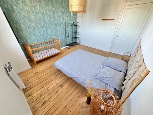 une chambre avec un lit et un parquet dans l'établissement Double appartement jusqu'à 14 personnes en hypercentre de Berck-Plage, à Berck-sur-Mer