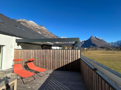 two chairs and a table on a deck with mountains at Sunny AP22 in Bovec