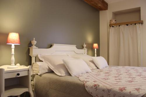 a bedroom with a large white bed with white pillows at L'Ancienne Boulangerie in Chavagnes