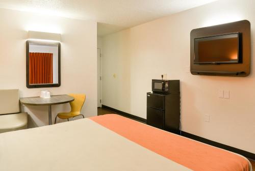 a hotel room with a bed and a tv on the wall at Motel 6-Toledo, OH in Maumee