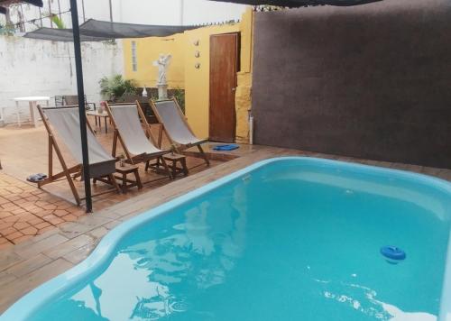a large swimming pool with chairs and a table at Casa Mali, zona centro, con piscina, asador y muy amplia in Ciudad Valles
