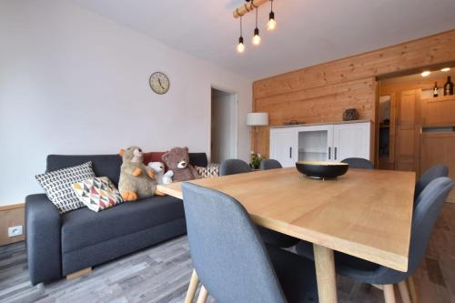 - un salon avec un canapé bleu et une table en bois dans l'établissement 6-bed apartment at the foot of the slopes, à Briançon