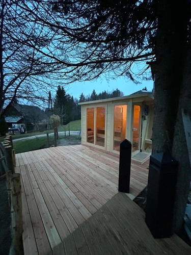 a house with a wooden deck and a tree at Fridas Place - DER Blick über ganz Villach - 160 m2 Ferienoase - ganzes Haus bis zu 8 Personen in Villach