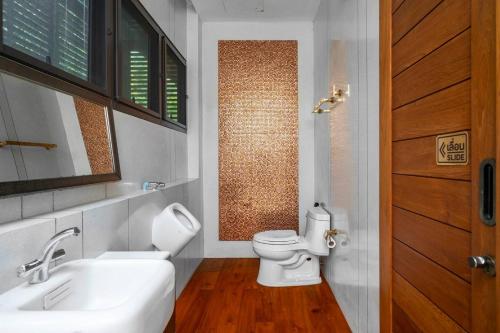 a bathroom with a white toilet and a sink at The Height Khaoyai Resort in Ban Huai Sok Noi