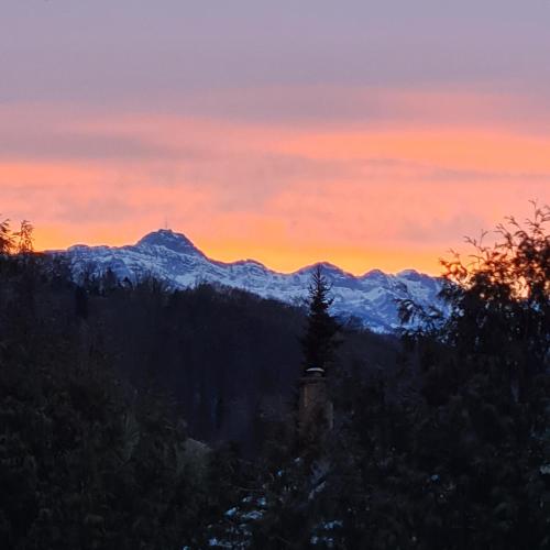 a sunset in the mountains with snow covered mountains at Auszeitoase am Wald und Bach in Kradolf