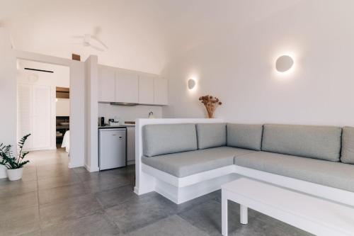a living room with a couch and a kitchen at Makrikythera Luxury Suites - Private Pool or Hot Tub Suites in Dhiakofti