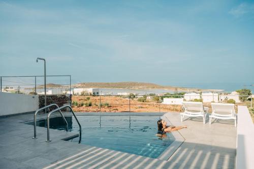 a woman is in a swimming pool at Makrikythera Luxury Suites - Private Pool or Hot Tub Suites in Dhiakofti