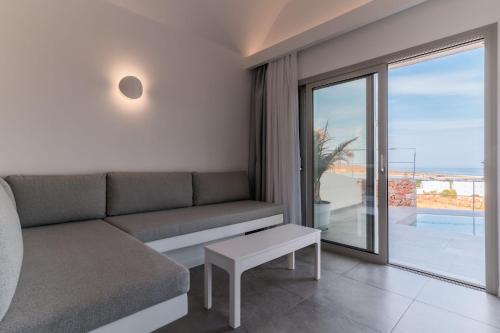 a living room with a couch and a view of the ocean at Makrikythera Luxury Suites - Private Pool or Hot Tub Suites in Dhiakofti