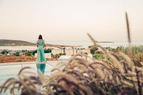 a woman in a green dress standing on top of a building at Makrikythera Luxury Suites - Private Pool or Hot Tub Suites in Dhiakofti