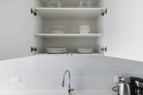 een keuken met borden boven een gootsteen bij Blueground The Loop pool wd nr par CHI-1186 in Chicago