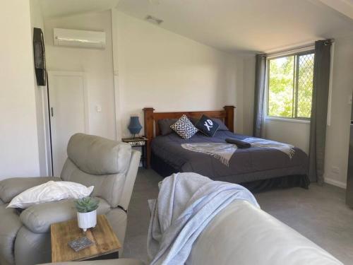 ein Wohnzimmer mit einem Bett und einer Couch in der Unterkunft Rosehill cottage and bush retreat in Glastonbury