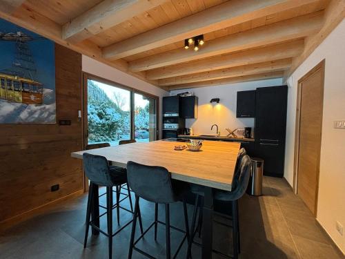 une cuisine avec une grande table et des chaises en bois dans l'établissement Chalets, Les Crozats, à Montriond