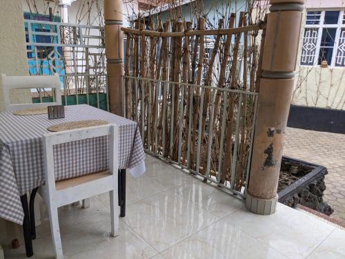 a table and chairs on a balcony with a fence at SAISH Stay in Ruhengeri