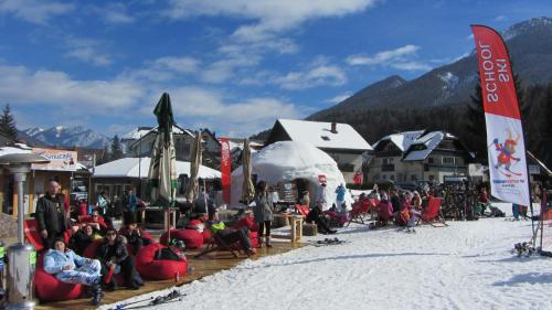 a crowd of people sitting in chairs in the snow at Apartment Jakelj in Kranjska Gora