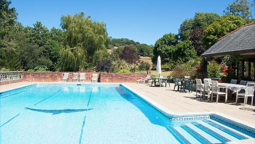 una piscina con sillas, mesa y sillas en Malston Mill Farm, en Kingsbridge
