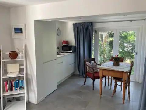 a kitchen with a dining room table and a table and chairs at Unit at Kohimarama in Auckland
