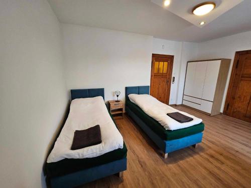 レンボルクにあるApartament Czołgistów Centrumのベッド2台とテーブルが置かれた寝室