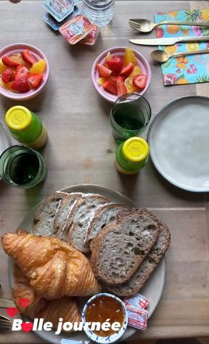 a table with plates of bread and bowls of fruit at Manoir la grande guerais in Beaussais sur Mer