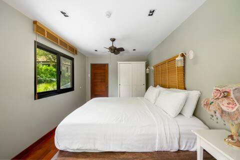 a bedroom with a large white bed and a window at The Height Khaoyai Resort in Ban Huai Sok Noi