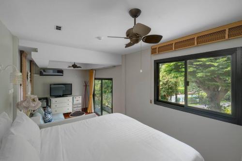 a bedroom with a white bed and a window at The Height Khaoyai Resort in Ban Huai Sok Noi