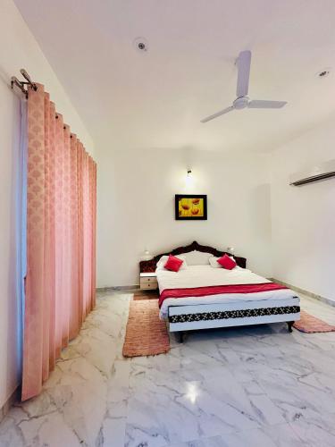 a bedroom with a bed with red pillows at Golden Oriole House in Jairāmpura