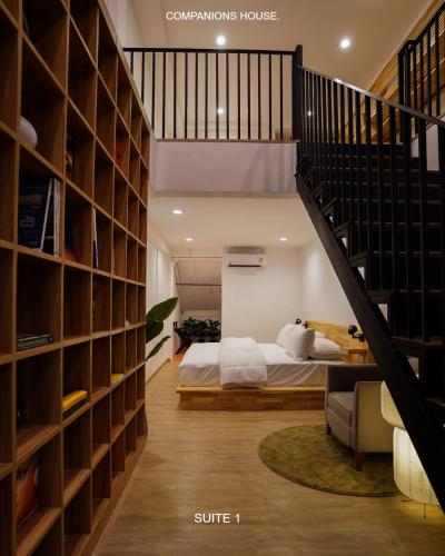 a bedroom with a bed and a book shelf at The companions house in Sathani Bang Su