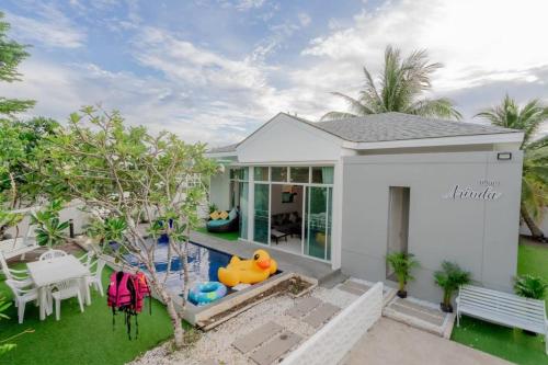 a white house with a pool and a backyard at City Beach 2 Cha-am Pool Villa in Cha Am