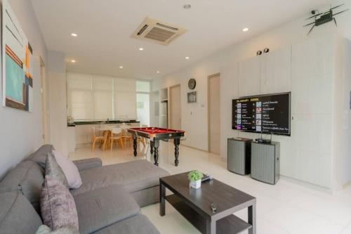 a living room with a couch and a ping pong table at City Beach 2 Cha-am Pool Villa in Cha Am