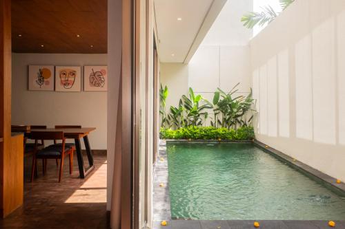 an indoor swimming pool in the middle of a house at Kayumas Seminyak Resort in Seminyak