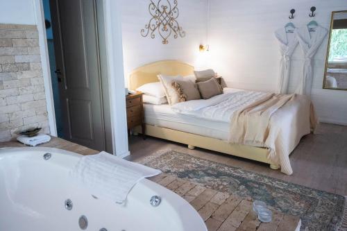 a bedroom with a bed and a bath tub at קאסה בלנקה- Casa Blanca רמות in Moshav Ramot