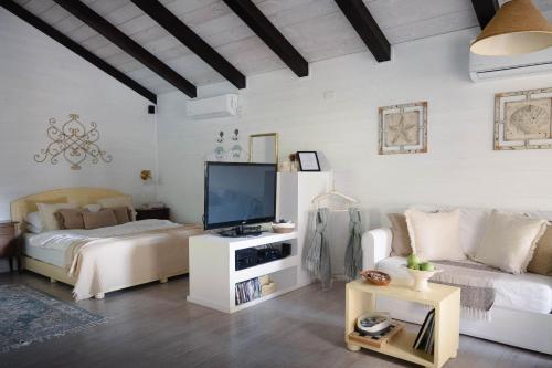 a bedroom with a bed and a tv and a couch at קאסה בלנקה- Casa Blanca רמות in Moshav Ramot